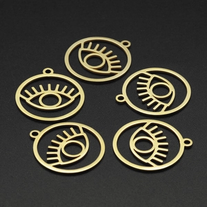 Five gold stainless steel hollow evil eye pendants for DIY jewelry making on black background