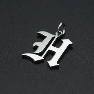 Macro-opname van zilveren gotische letter H hanger van gepolijst roestvrij staal voor sieraden