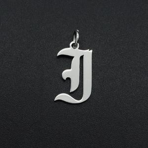 Gedetailleerd macro-aanzicht van een zilveren gotische letter J hanger van roestvrij staal