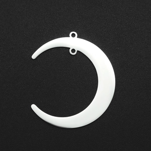 Detailed view of polished crescent moon stainless steel jewelry charms on dark surface