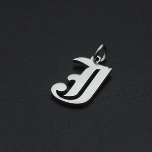 Macro-opname van gotische letter J hanger van gepolijst roestvrij staal voor DIY sieraden
