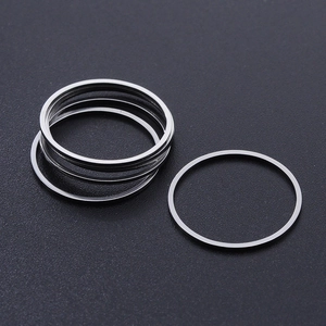Macro detail of minimalist silver stainless steel thin rings on a black matte background