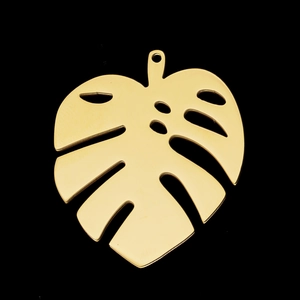 Detalle de un colgante de hoja de Monstera en acero inoxidable dorado pulido para joyería