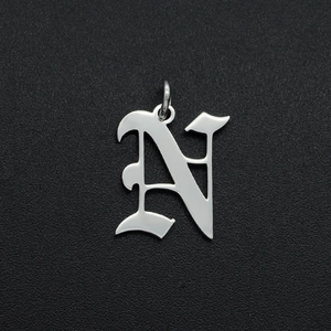 Detailopname van gepolijste zilveren roestvrijstalen letter N hanger voor sieraden
