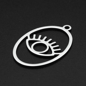 Macro shot of silver stainless steel evil eye pendant with cutout geometric details