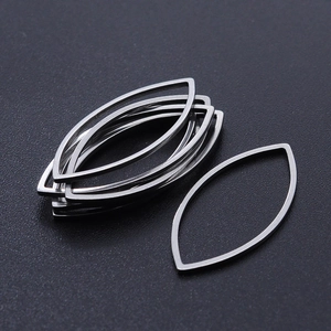 Close-up of silver-tone marquise eye-shaped hollow stainless steel jewelry charms for DIY