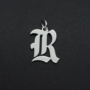 Macro-opname van een gepolijste roestvrijstalen gotische letter R hanger voor sieraden