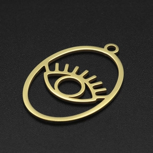 Detail of a gold-plated evil eye geometric pendant with eyelashes for DIY jewelry making