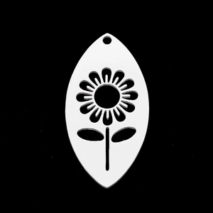 Vue macro d'un pendentif feuille en acier inoxydable argenté avec fleur évidée