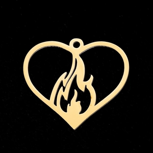 Détail d'un pendentif cœur doré avec motif flamme ajouré et boucle en métal pour bijoux