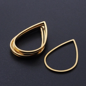 Macro view of golden teardrop stainless steel pendant frames for DIY jewelry making