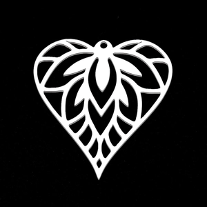 Détail macro d'un pendentif coeur évidé en acier inoxydable avec motifs floraux