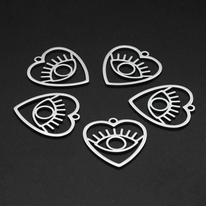Detailed view of heart-shaped evil eye pendants in stainless steel for DIY jewelry