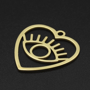 Detailed close-up of golden stainless steel heart-shaped evil eye pendant on black background
