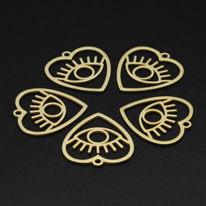 Detailed view of five gold heart-shaped evil eye charms for DIY jewelry making