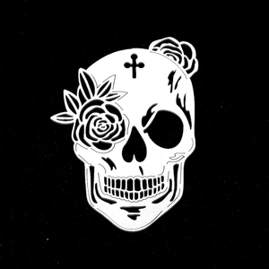 Macro shot of a gothic skull pendant with rose flowers and a cross cut-out detail
