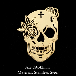 Detailed macro view of a 29x42mm golden stainless steel skull pendant with floral accents