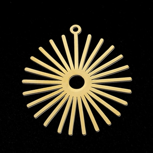 Vue macro d'un pendentif en forme de soleil doré avec anneau central sur fond noir profond