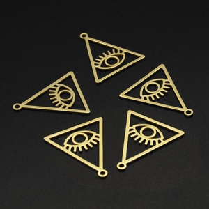 Macro view of five triangular evil eye pendants in matte gold for DIY jewelry projects