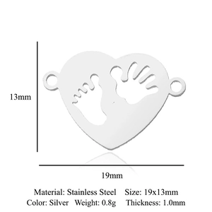 Macro detail of heart-shaped stainless steel pendant with baby footprint engraving