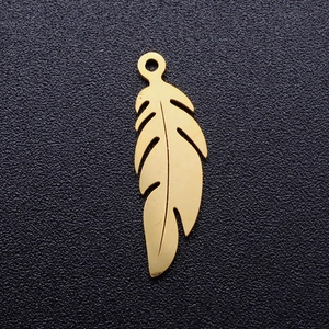 Détail d'un pendentif plume en acier inoxydable doré avec un design ajouré élégant