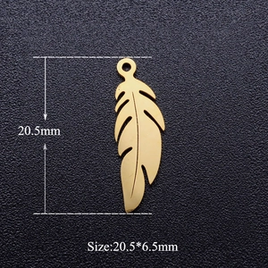 Vue macro d'un pendentif plume en acier doré montrant les dimensions 20,5mm sur 6,5mm