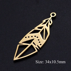 Vue macro d'un pendentif plume en acier inoxydable doré 34x10,5mm avec découpes géométriques