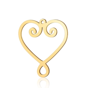 Macro view of gold heart pendant with intricate scrollwork and smooth metallic finish
