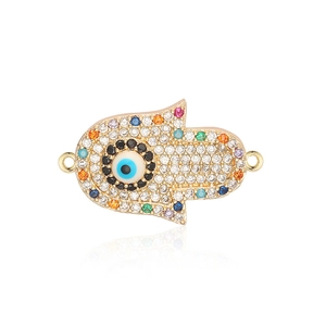 Macro view of gold Hamsa hand charm with cubic zirconia and blue evil eye detail