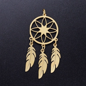 Macro detail of a golden lotus dreamcatcher pendant with three delicate feather charms