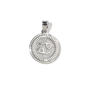 Macro shot of silver Cancer zodiac charm with fine glitter inlay and radial sunburst texture
