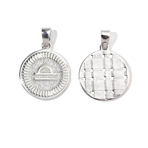 Silver Libra zodiac charm with celestial sunburst design and textured reverse side