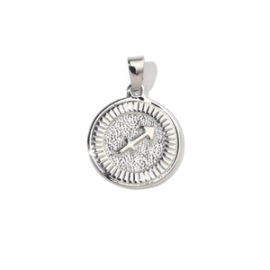 Macro shot of silver Sagittarius coin charm with vintage relief and sunburst edge
