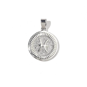 Macro shot of silver-colored circular Pisces zodiac charm with engraved astrological symbol