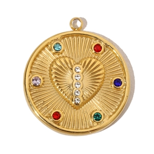 Detailed macro view of a vintage sunburst gold pendant with heart relief and colorful gems