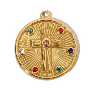 Macro shot of gold stainless steel cross pendant with colorful gemstones in detail