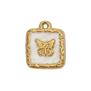 Detailed close-up of a golden butterfly pendant with white enamel on a textured metal base