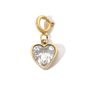 Macro shot of a golden heart pendant with a sparkling crystal and spring ring clasp