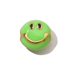 Macro view of a green enamel smiley face pendant with gold stainless steel plating