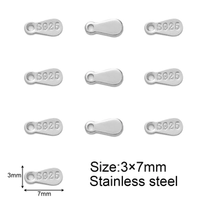 Macro shot of 3x7mm stainless steel teardrop jewelry tags with S925 engraving detail