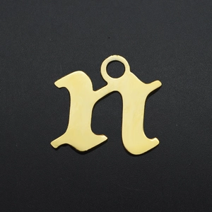 Macro shot of gold-plated stainless steel letter n pendant with polished Gothic design