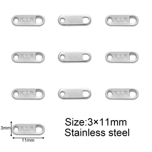 Macro view of oval stainless steel jewelry tags with K18 engraving for extension chains
