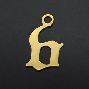 Macro detail of gothic style gold plated stainless steel letter pendant with polished finish