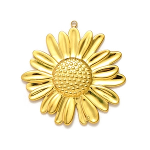 Détail macro du pendentif tournesol doré avec texture en relief et finition polie