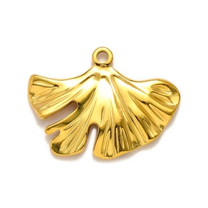 Dettaglio di un ciondolo a foglia di ginkgo dorato con delicate venature e anello