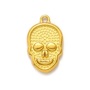 Vue détaillée d'un pendentif tête de mort doré avec texture à pois et petit anneau