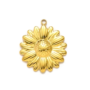 Dettaglio di un ciondolo a girasole dorato con petali in rilievo e anello di metallo lucido