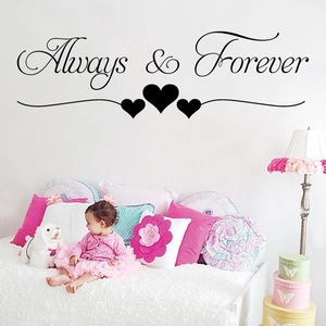 Détail du sticker mural Always & Forever en vinyle noir au-dessus d'un lit douillet