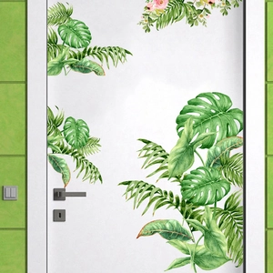 Macro detail of tropical green monstera leaf and pink floral wall decals on a white door