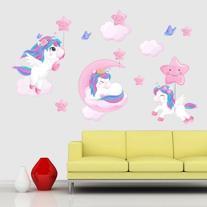 Detail view of unicorn and star wall stickers on a grey wall above a yellow sofa